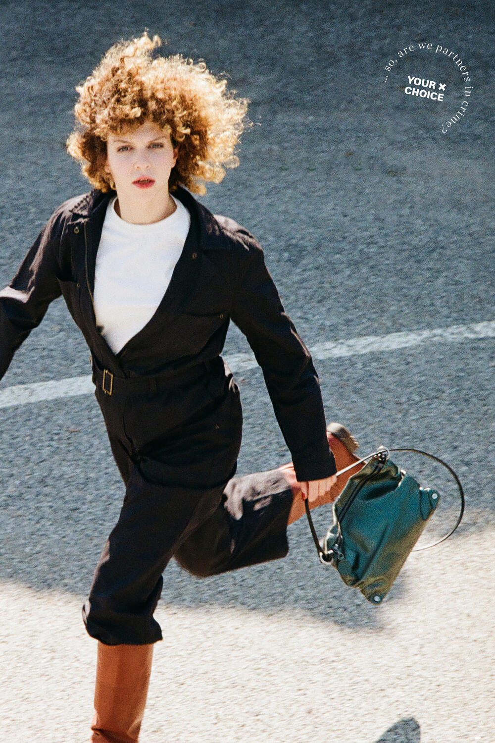 A person with curly hair in a dark outfit walks briskly on a road, holding an INA KENT green bag. Text on the image reads, "Your choice," followed by "Join Are We Partners in Traffic.”