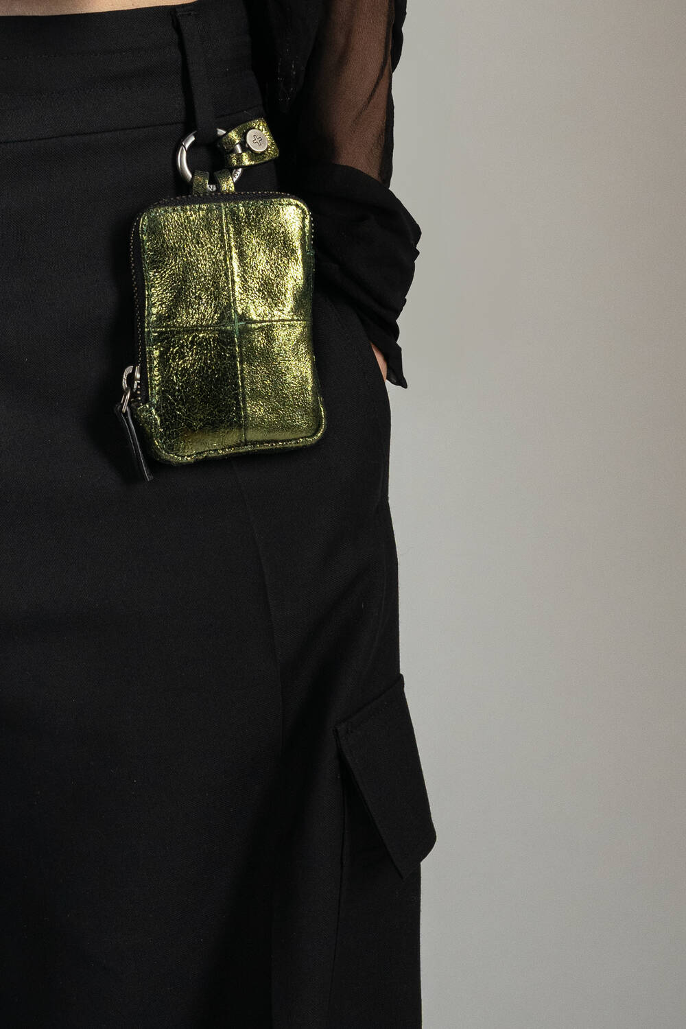INA KENT X.LOMI ed.2 aus Metallic-Leder in grün getragen an der Gürtelschlaufe einer schwarzen Hose