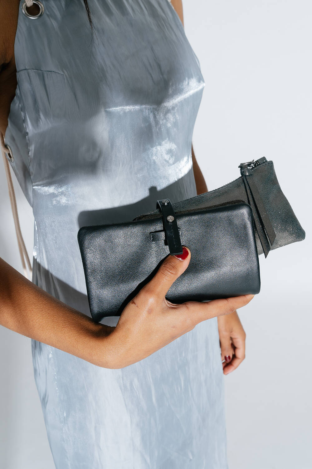 Frau mit rot lackierten Nägeln hält eine Chiefy ed.1Geldtasche in die Kamera 