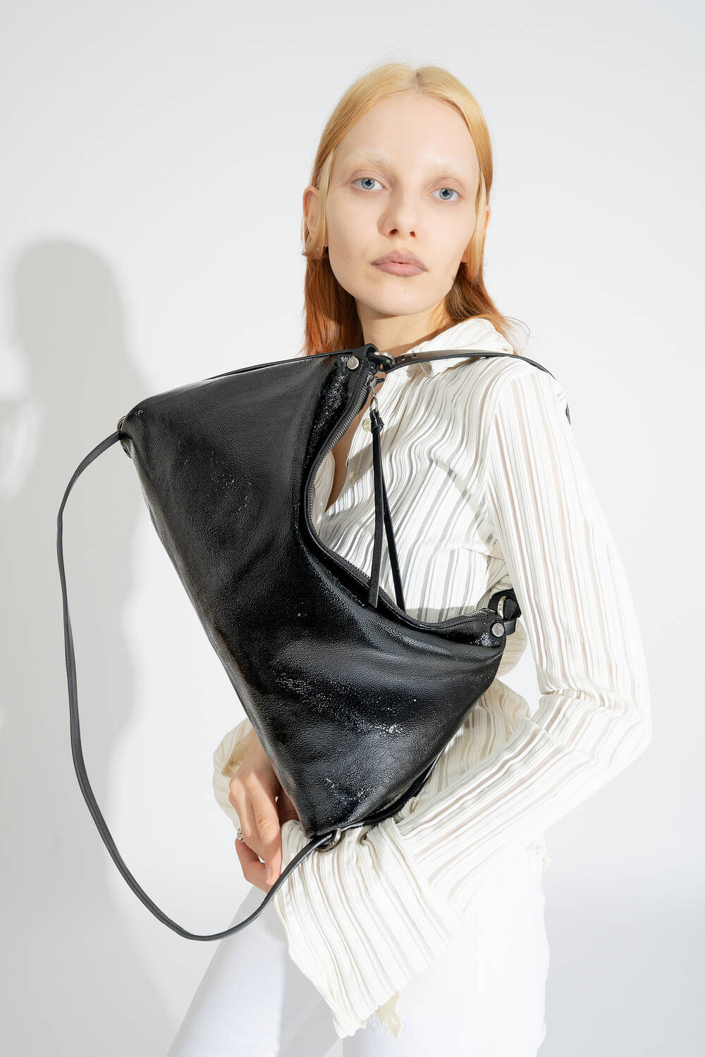 INA KENT DINKUM ed.2 bag in patent ink black is worn as a shoulder bag, the simple style emphasizes its versatility.