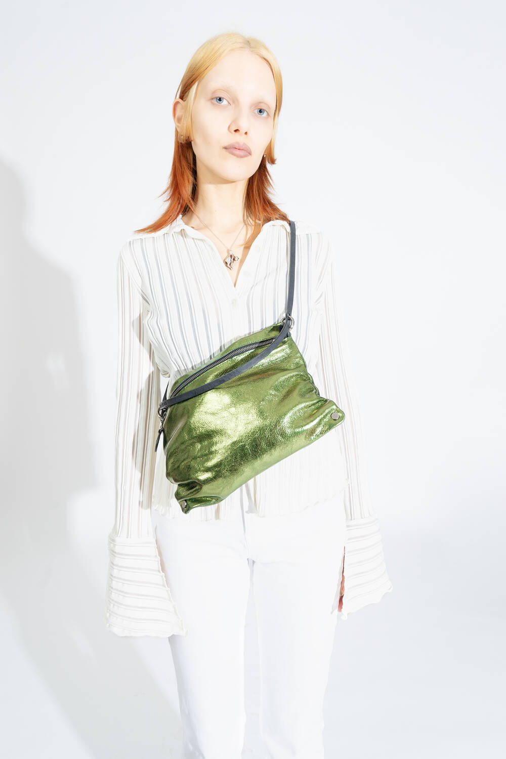 INA KENT bag MOONLIT ed.1 in crackled guacamole is worn diagonally across the chest.