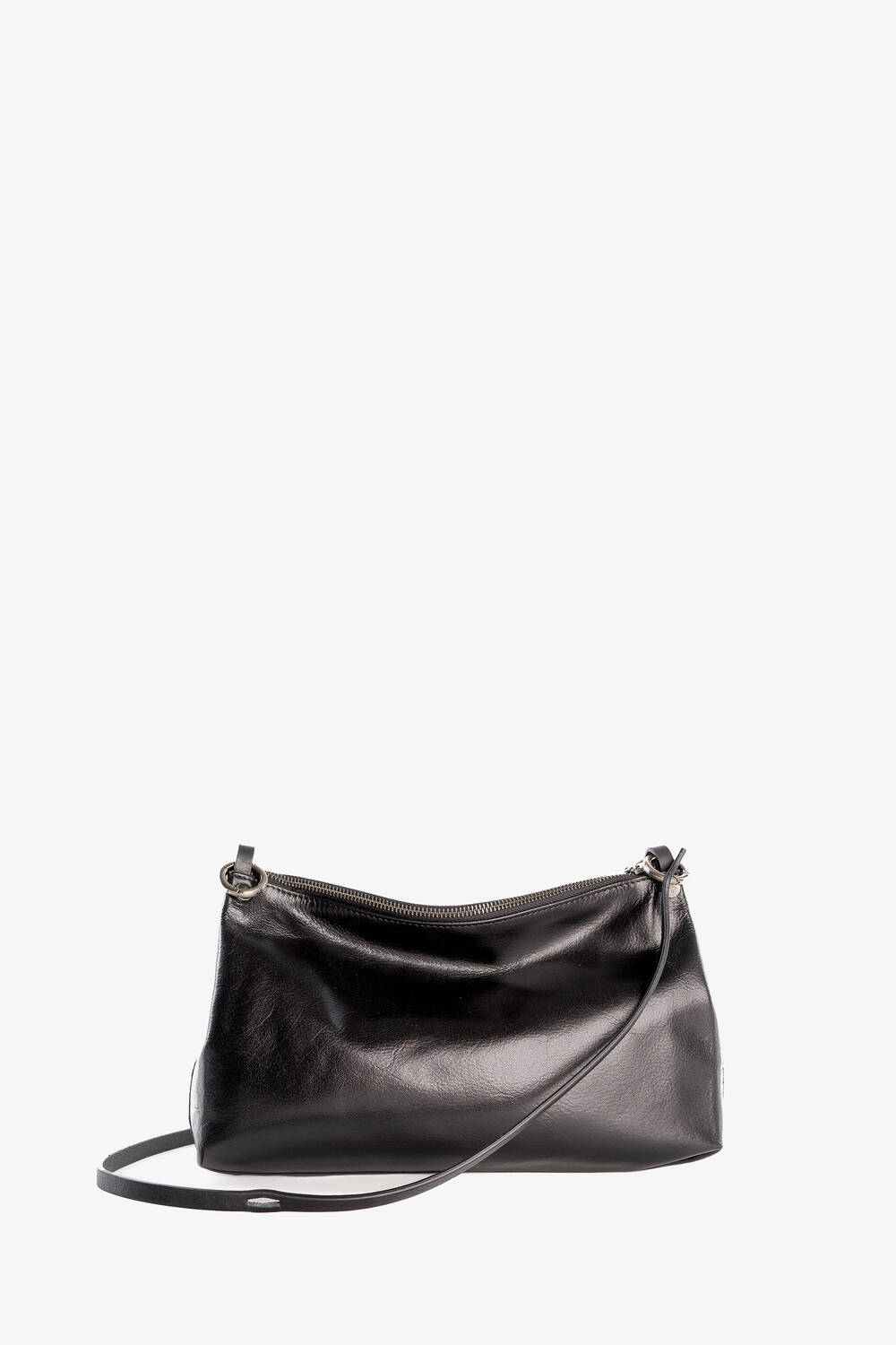 Eine schwarze Umhängetasche aus Leder von INA KENT mit dünnem Riemen und Reißverschluss oben, präsentiert vor einem schlichten weißen Hintergrund.