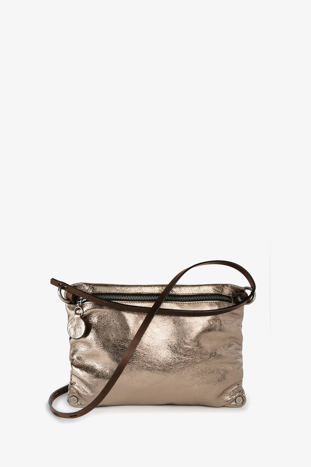 INA KENT Crossbody Bag in Goldmetallic mit Reißverschluss, kleinem runden Anhänger und dünnem verstellbaren Riemen auf weißem Hintergrund.