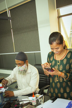 Ina Kent beim Produktionspartner, Frau am Smartphone, lachend