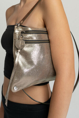 A person wearing a black tube top and holding a metallic silver INA KENT handbag with a keychain.