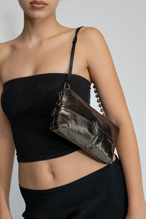 Person wearing a black tube top and skirt holds an INA KENT metallic shoulder bag.