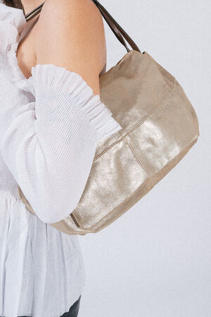 A person with a white, off-the-shoulder top carries an INA KENT beige handbag with metallic sheen over their shoulder.