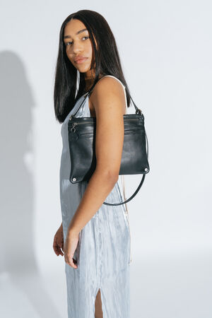 Female with black smooth leather shoulder bag from INA KENT.