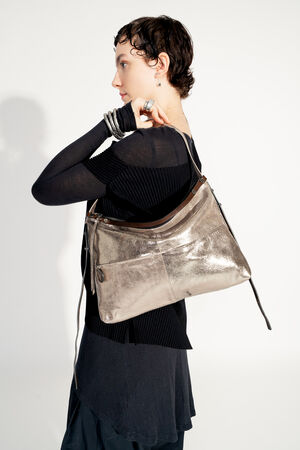 Model with INA KENT ROVE ed.3 metallic bright anthra (sideways, view from behind): The bag is worn sideways, the focus is on the shiny surface and the minimalist details. The model presents the bag in a modern, monochrome style.