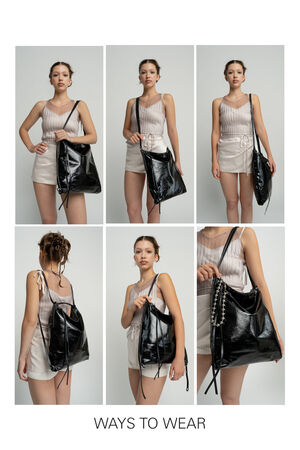Six pictures of a female read person showing different ways of carrying the AMPLE ed.1 bag in black patent leather. The person is wearing a light-colored outfit with a sleeveless blouse and short shorts. The bag is worn over the shoulder, as a crossbody and on the arm. One of the variants shows the bag with a decorative chain. The background is kept neutral in light gray, the focus is on the bag and its versatile carrying options. 