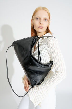 NA KENT Tasche DINKUM ed.2 in patent ink black wird als Schultertasche getragen, der schlichte Stil unterstreicht die Vielseitigkeit.