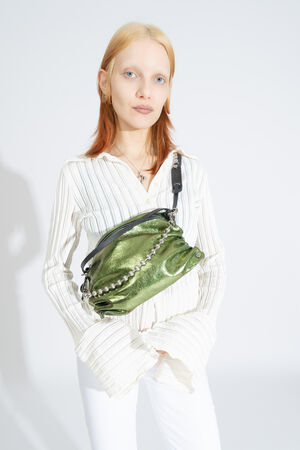 INA KENT Tasche MOONLIT ed.1 in crackled guacamole wird diagonal über die Brust getragen, kombiniert mit einer Kugelkette.