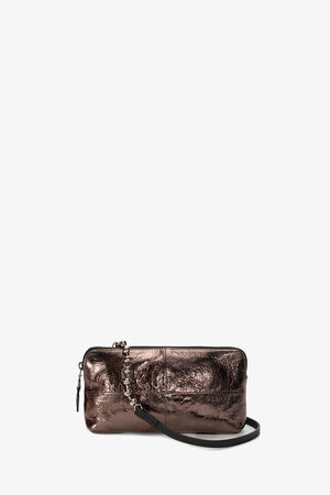 INA KENT presents a metallic bronze clutch bag with a zipper and black wrist strap, enhanced by a stylish chain attachment on the side. Set against a plain white background, this piece seamlessly combines functionality with contemporary design.