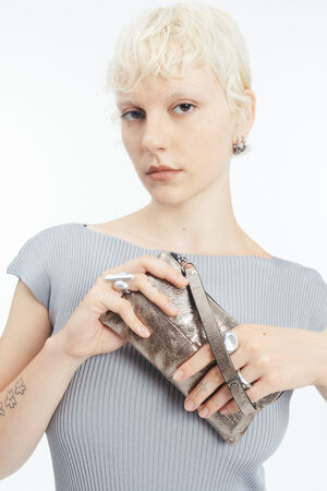 Blondes Model mit goldenem Portemonnaie aus Metallic Leder