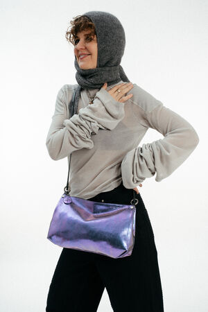 Weiblich gelesenes Model mit lila-blauen Tasche Crossbody