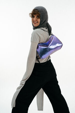 Weiblich gelesenes Model mit lila-blauen Tasche auf der Schulter