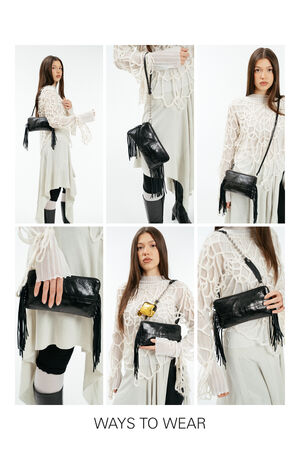 A woman demonstrates six different ways to style the INA KENT black fringe handbag, including crossbody, over the shoulder, and as a clutch, while wearing a white patterned top and a light skirt.