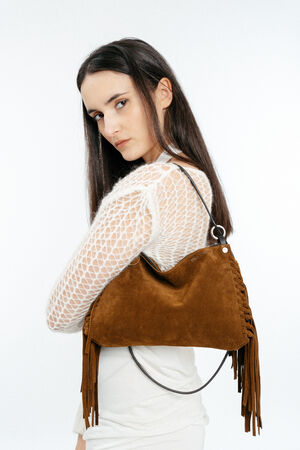 Woman in a white mesh top poses with an INA KENT brown suede fringe handbag over her shoulder against a plain white background.