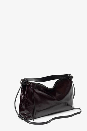 A dark burgundy INA KENT patent leather shoulder bag with a long adjustable strap, silver hardware, and a soft, slouchy shape on a white background.