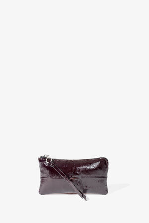 Kleine, rechteckige, dunkelbraune Handgelenktasche aus Lackleder von INA KENT mit Reißverschluss und passendem Handgelenkriemen, präsentiert vor einem schlichten weißen Hintergrund.