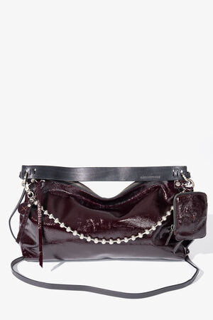 A glossy dark burgundy INA KENT handbag with a silver chain detail, zip closure, small attached pouch, and a long black strap, displayed against a plain white background.