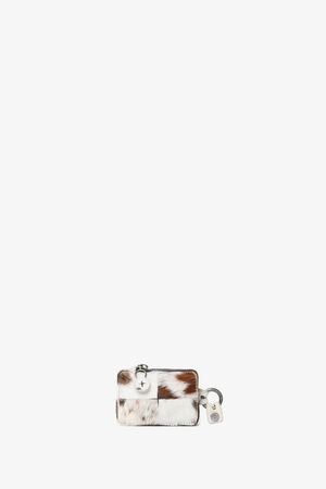 Small rectangular INA KENT wallet with a brown and white fur pattern, silver zipper, and matching keychain tag, displayed on a plain white background.