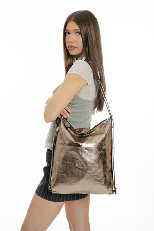 A metallic bronze INA KENT hobo-style shoulder bag worn by a person.