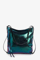 A metallic, iridescent INA KENT shoulder bag with black straps and decorative tassels, displayed against a plain white background.