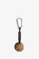 A silver carabiner keychain with a black leather strap and a round gold medallion featuring a star and the word "DESPERADO," inspired by INA KENT’s signature minimalist style.