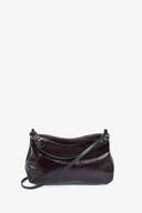 A small, dark burgundy INA KENT leather crossbody bag with a shiny finish, zippered top, and thin adjustable strap against a plain white background.