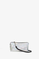 Rectangular silver iridescent clutch bag by INA KENT, featuring a black strap and zipper closure, set against a plain white background.