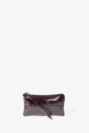 A small, dark brown patent leather INA KENT wristlet pouch with a zipper closure and wrist strap, displayed against a plain white background.