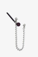 A silver ball chain with two lobster clasps, a dark round tag with an X, and a slim leather tab—signature elements of INA KENT—are arranged elegantly against a white background.